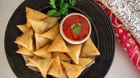 Triangular chicken samosas on a platter
