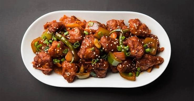 Bowl of chicken chilli garnished with spring onion